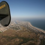 The distinctive tail of the B-24 is visible as the plane flies over West Newport and Banning Ranch, with the harbor visible in the distance. Photo by Jim Collins