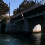 A teen jumps from the Lido Bridge last week, despite increased police enforcement against the activity. Photo by Eric Longabardi