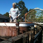 Dennis Holland works on what's left of the Shawnee in his side yard. Photo by Eric Longabardi