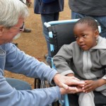 Don Schoendorfer, founder and president of Free Wheelchair Mission, gives a child a much-needed wheelchair.