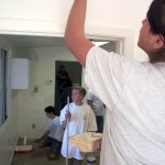Andrea Ortega, 13, paints the SOY office on Saturday as NLYM boys work in the next room.
