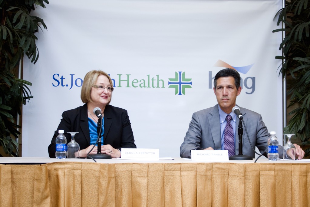 Deborah Proctor, president and CEO of St. Joseph Health, and Dr. Richard Afable, Hoag president and CEO, speak about the affiliation at a conference on Wednesday.