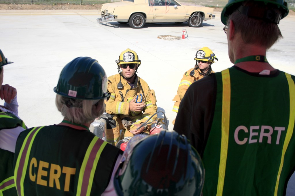 Newport Beach firefighters Jimmy Strack (left) and Jake Long explain the details of fire extinguishers to CERT volunteers.