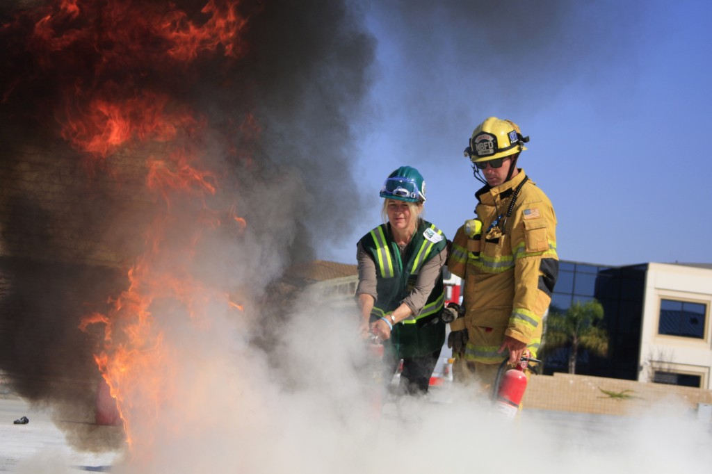 CERT Drill the Skills 2012 Newport Beach firefighter Jimmy Strack helps a Community Emergency Response Team volunteer extinguish a fire at Saturday's "Drill the Skills" event. — All photos by Sara Hall