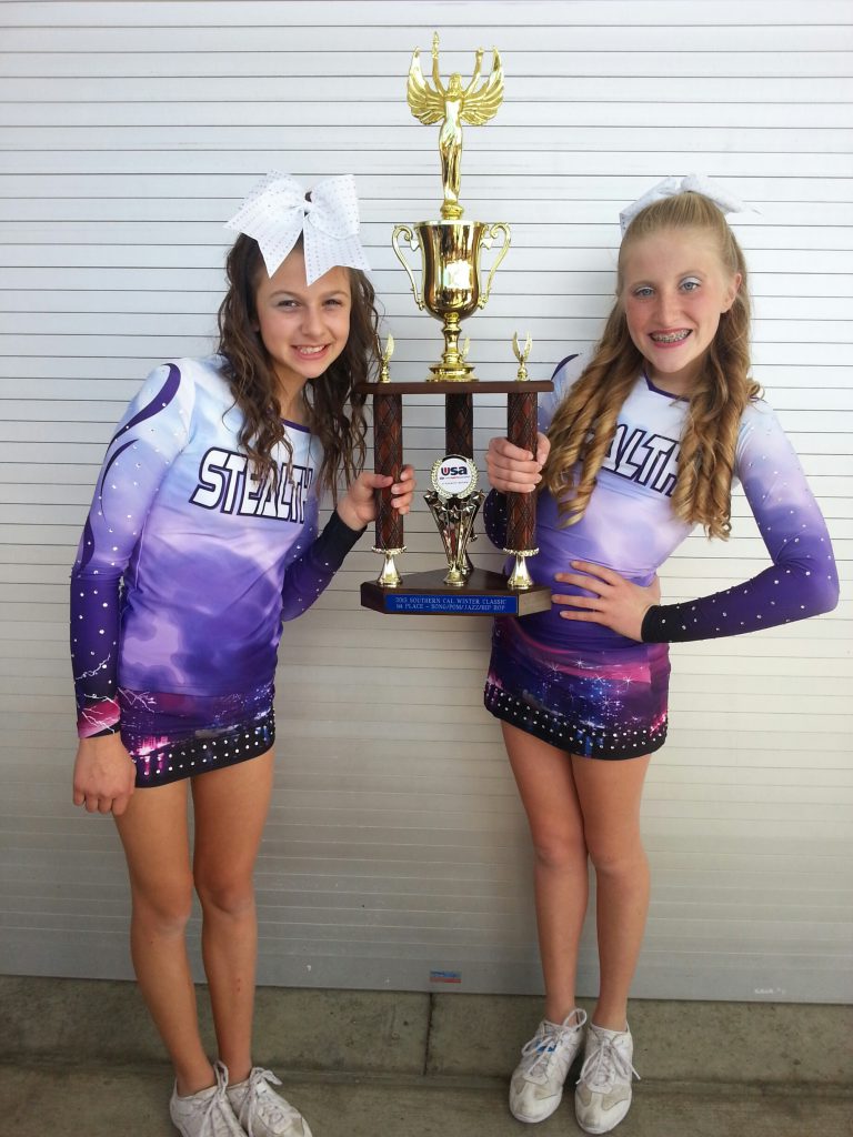 Janey Fales of Costa Mesa and Megan O'Connor of Newport Beach, members of the Stealth cheer team, take a moment to enjoy the fruits of their labors. Their team took first place in a tournament in San Diego last weekend. — Photo by Debi O'Connor  