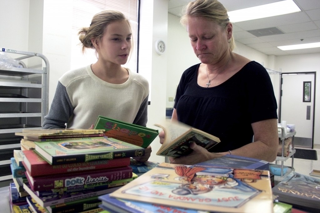 Ellen Kathcart (right) and her daughter Emma, 13, organize books by reading level.