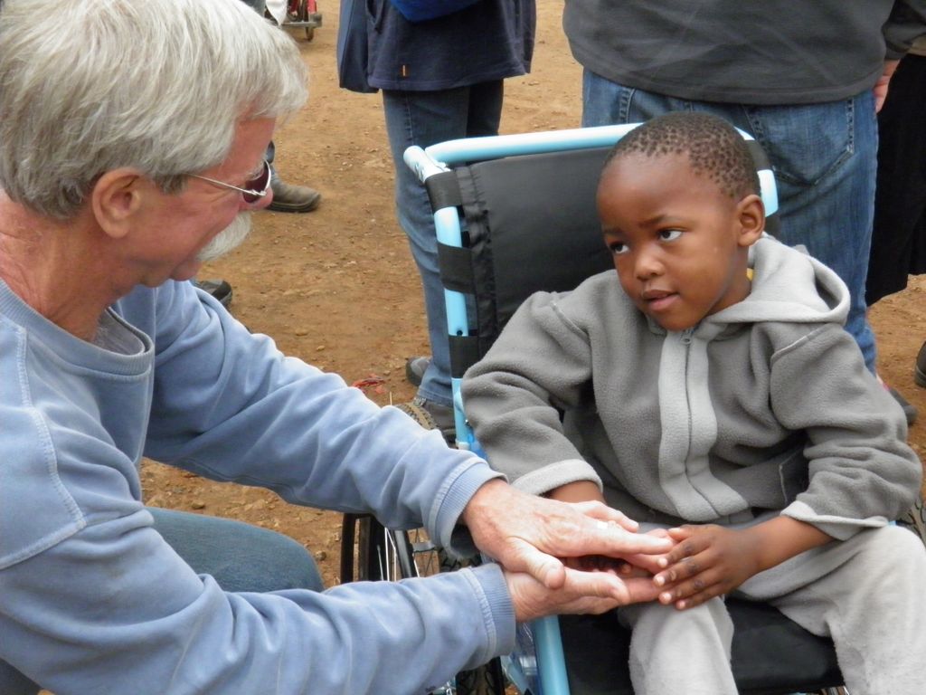 Don Schoendorfer, founder and president of Free Wheelchair Mission, gives a child a much-needed wheelchair.