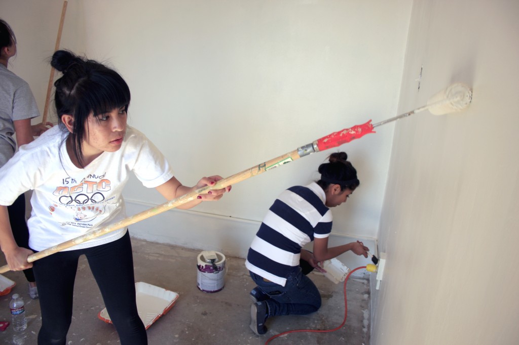 Brenda Vargas, 17, (left) and Wendy Delarosa, 15, from Estancia High School work on painting the SOY office.