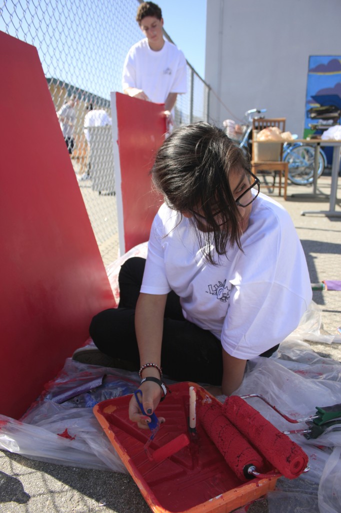 April Pedroza, 15, a student at Early College High School, paints a door at the SOY center alongside NLYM member Chase Braun, 14.