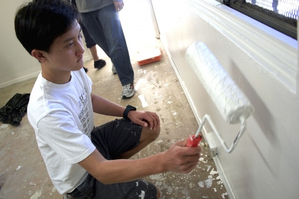 Connor Chung, 15, Sage Hill School student, paints an office wall at SOY. He came with his dad, Henry, for the parent/son NLYM activity.