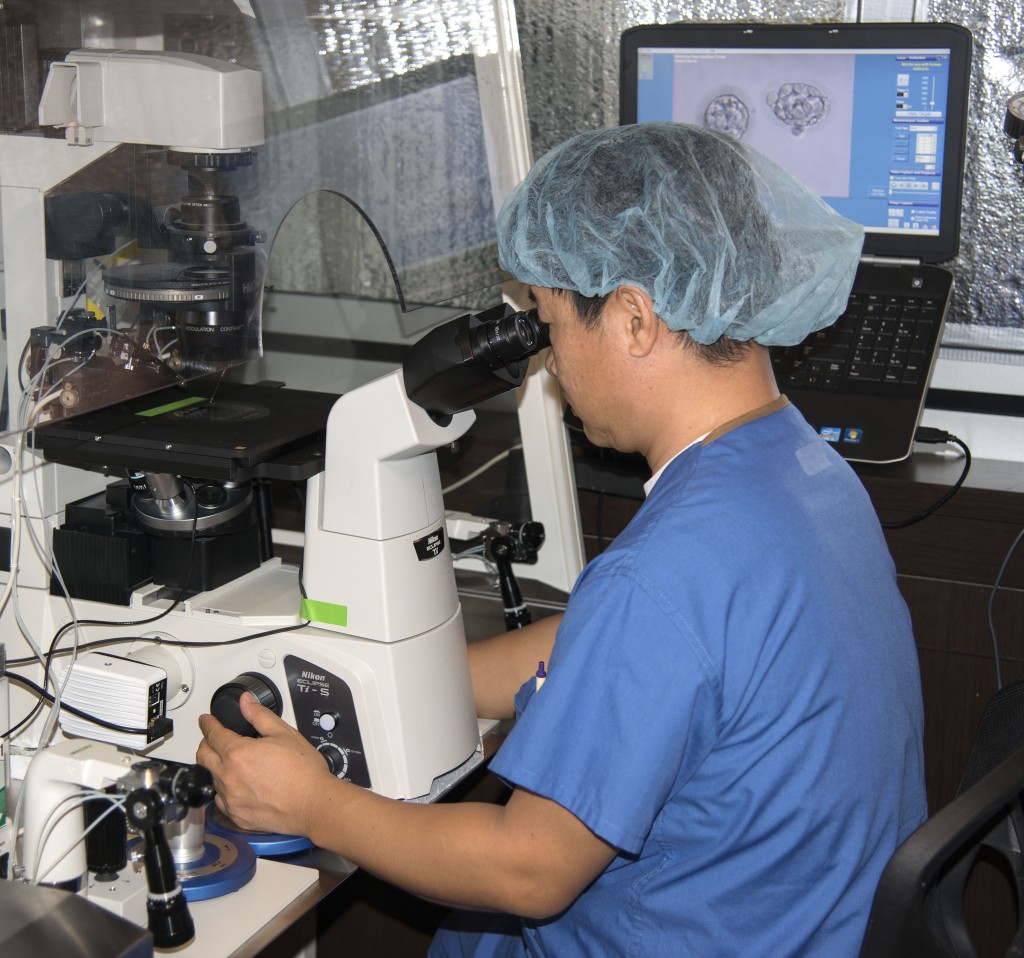 Hank Kim, the senior embryologist at the American Reproductive Center, demonstrates the microscope used to study embryos in the lab. — Photo by Charles Weinberg