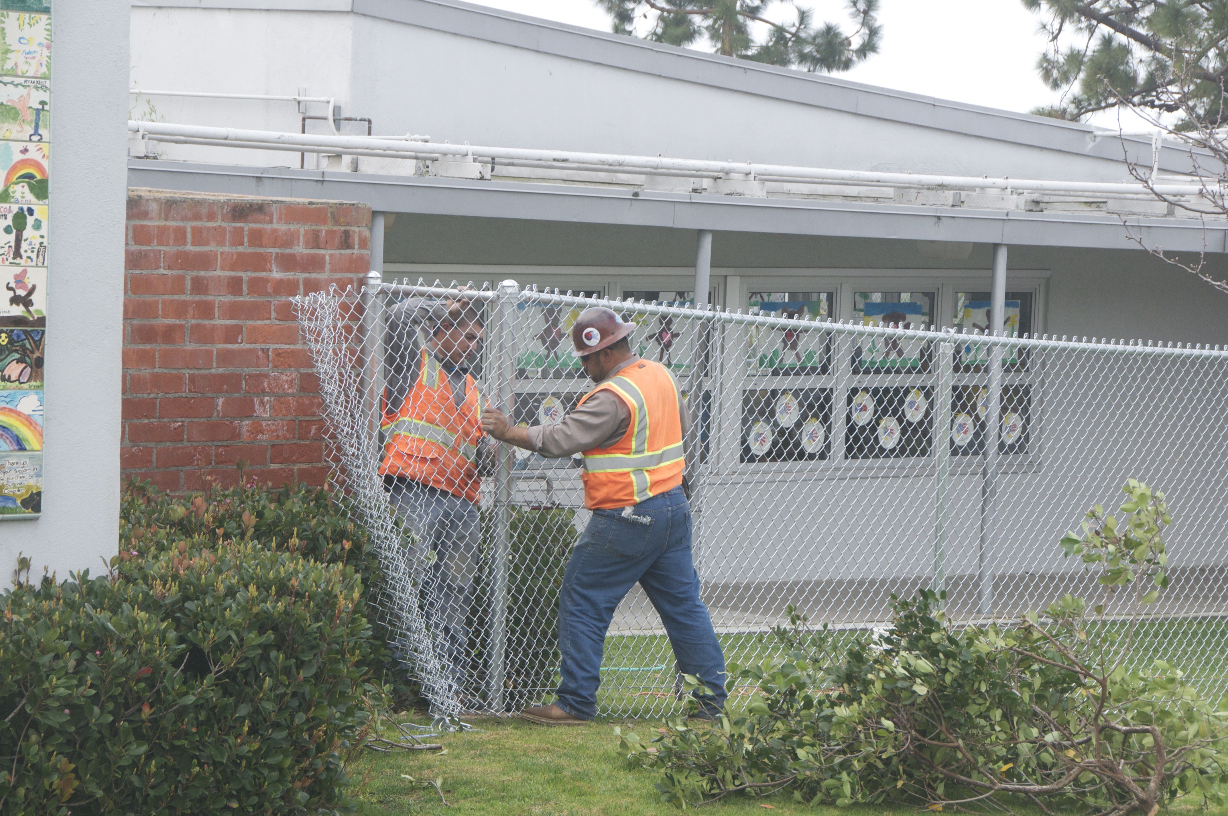 Crews install a fence for added security at Harbor View Elementary School