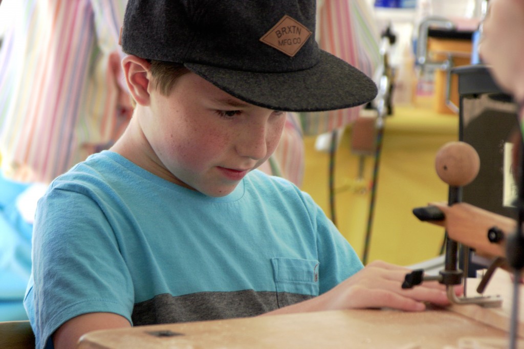 Landon Andrizzi, 11, crafts a wooden toy in the Kids’ Zone.