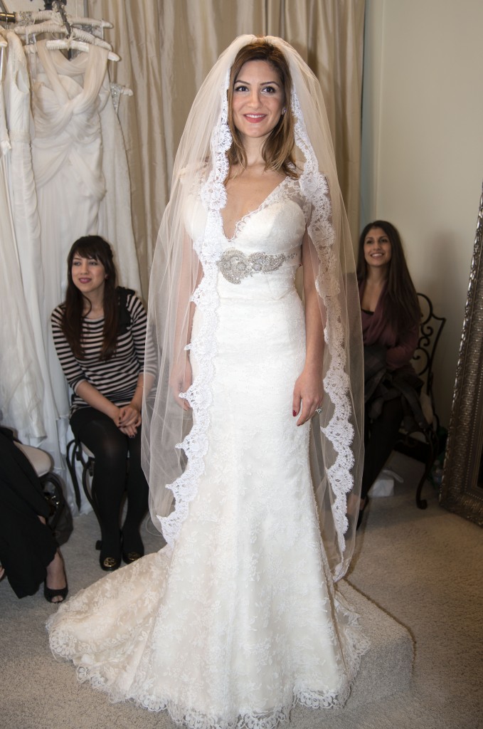 Neda Azarfar tries on a gown at The White Dress in Corona del Mar on Sunday. The shop was participating in the community’s bridal walk event. — Photos by Charles Weinberg.