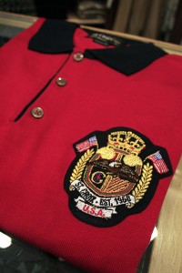 A red collared polo sports the shop’s logo.