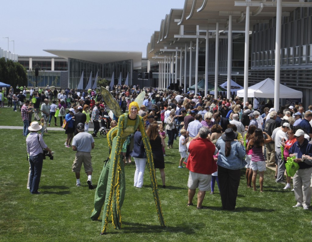 A lady grasshopper on stilts walks through the crowd at the civic center event. — Photo by Lawrence Sherwin