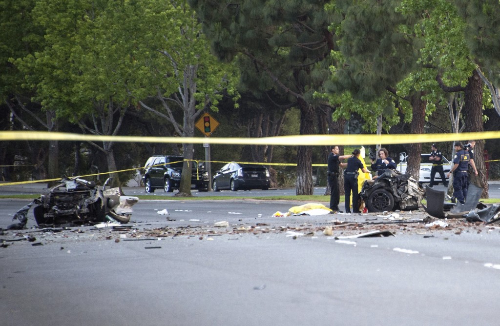 Law enforcement investigators sort through the wreckage of the single vehicle accident on Jamboree Road that killed five Irvine teens Monday evening. — Photo by Charles Weinberg