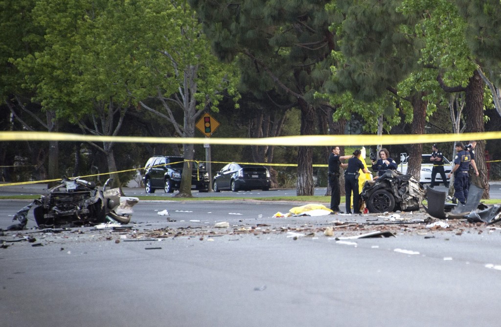 Law enforcement investigators sort through the wreckage of the single vehicle accident on Jamboree Road that killed five Irvine teens Monday evening. — Photo by Charles Weinberg 