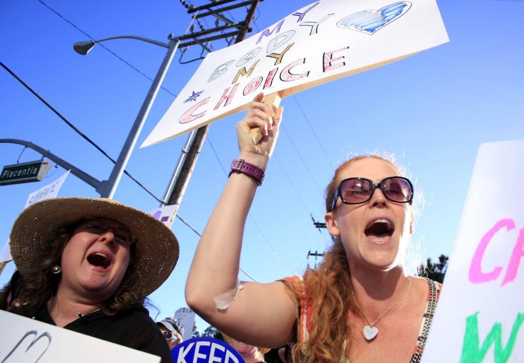 Hoag protestors (left to right) Yara Cuetara, co-president of Americans United for Separation of Church & State, Orange County chapter, and Erin Morgan of San Diego chant outside the hospital on Thursday.