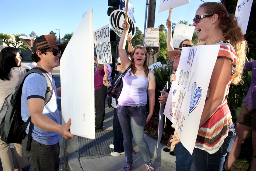 Pro-life demonstrator Paco Frausto of Huntington Beach (left) and pro-choice supporter Erin Morgan of San Diego argue as they wave signs at each other.