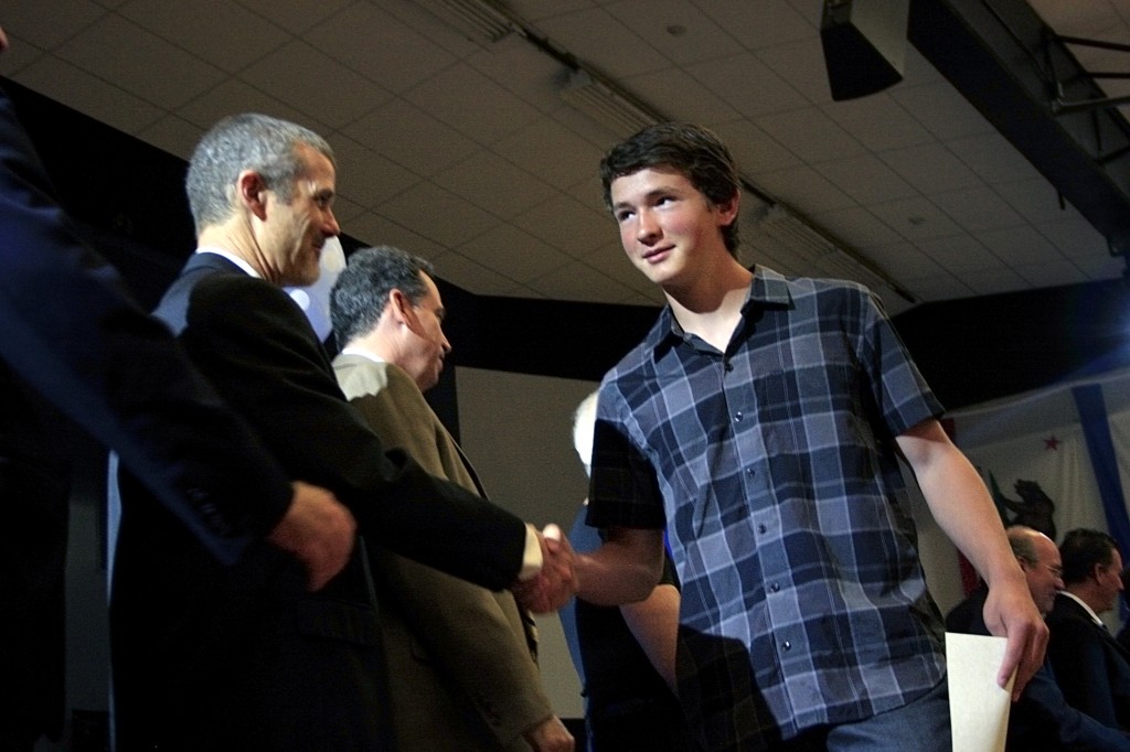 Harrison “Harry” Dill receives his award and shakes the hands of the honored guests.