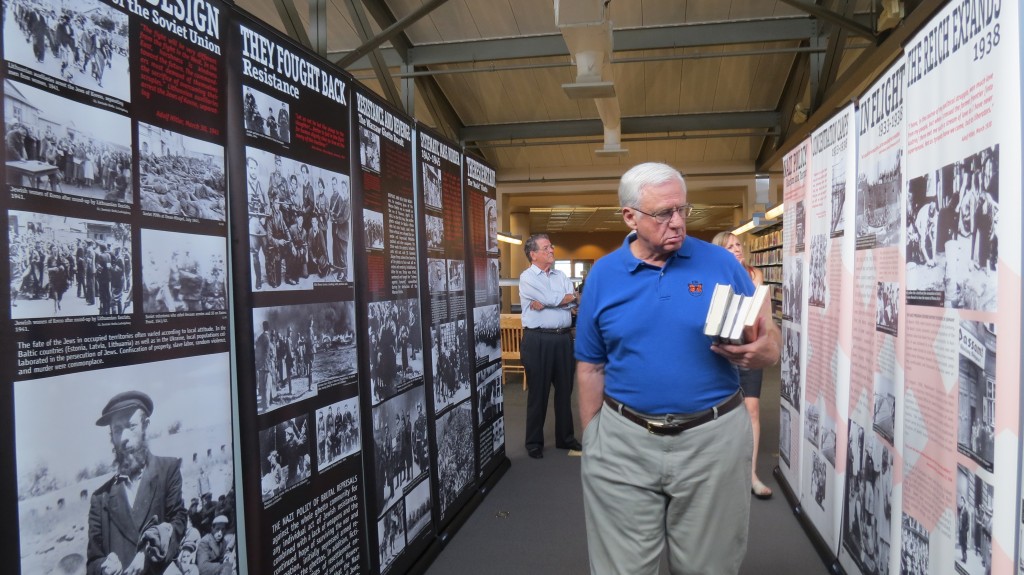 Visitors walk through the “Courage to Remember” exhibit at the Newport Beach Public Library on Monday. The 40-panel presentation documents the Holocaust and will be on display until July 29. — Photos by Elizabeth Greenberg