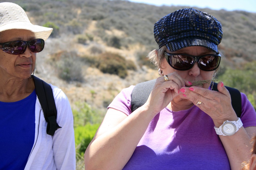 Eileen McCrickerd smells some sage, as Lauretta Herndon looks on. Both women have partial vision and became fast friends through the Braille Institute.