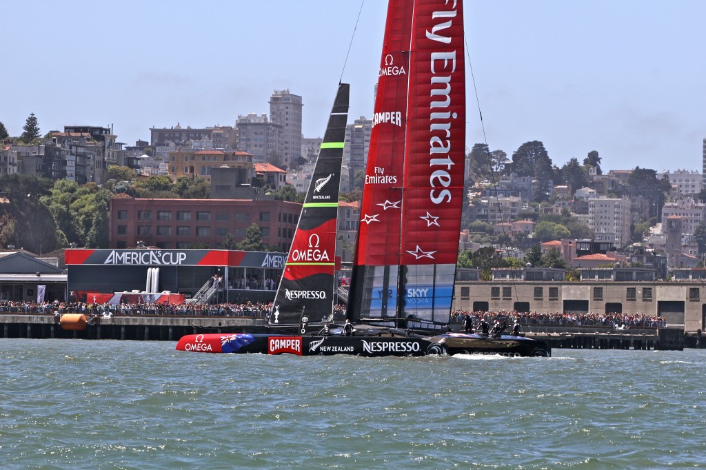 Team New Zealand finishes 5 minutes ahead of the competition during a heat at America's Cup race. A supportive crowd lined the shore.