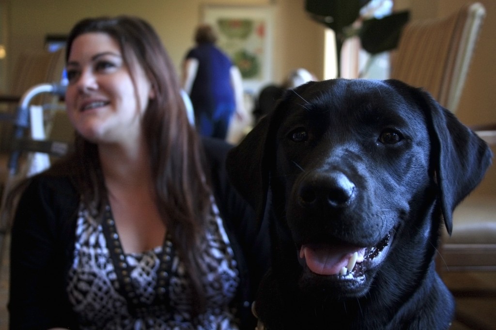 Raja, 8-month-old guide dog in training, with Jessilyn Guajardo, director of activities at Crown Cove senior living community in Corona del Mar.