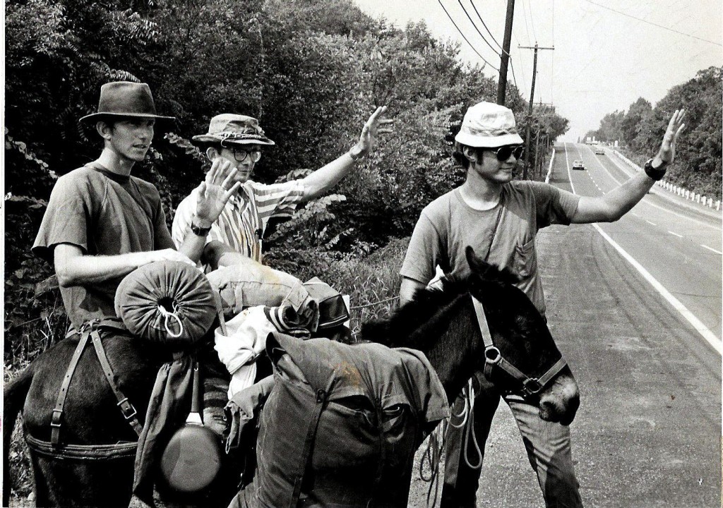 All three brothers waving to motorists as they walk along the road in the U.S.