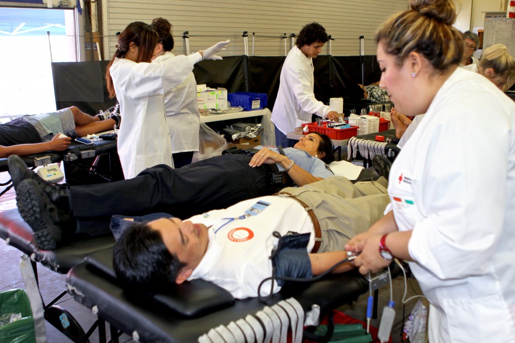 Frank Tran, a civil engineer associate in the city's public works department, and Valerie Schomburg, an animal control officer with Newport Beach Police Department, get their blood drawn on Wednesday.