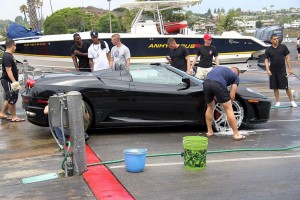 Only in Newport: volunteer members of the 1/1 wash a Ferrari during the July car wash fundraiser. The car’s owner offered one Marine a test drive which was accepted without debate. Photo by B.B. Yarborough. 