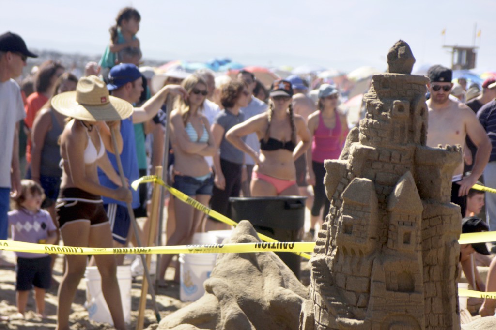 Spectators watch as contestants work on their sand sculptures at the 52nd Annual Sandcastle Contest at Big Corona State Beach on Sunday. — Photos by Sara Hall