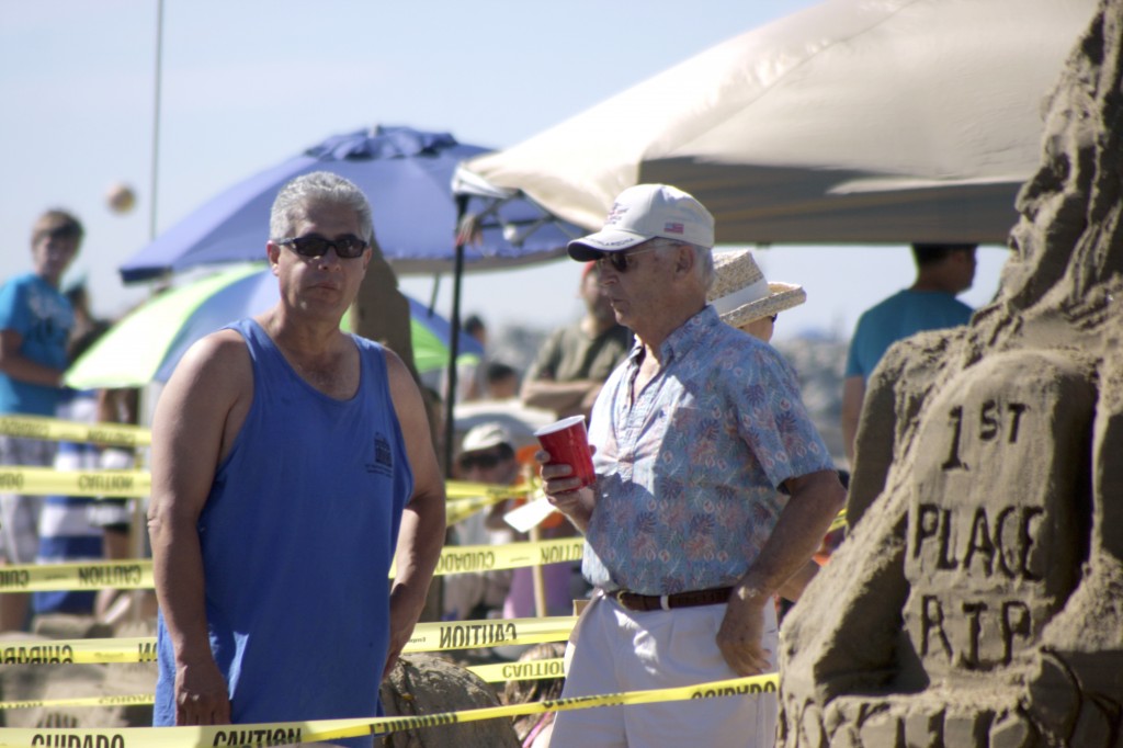 Spectators stand among the sandcastles on Sunday.