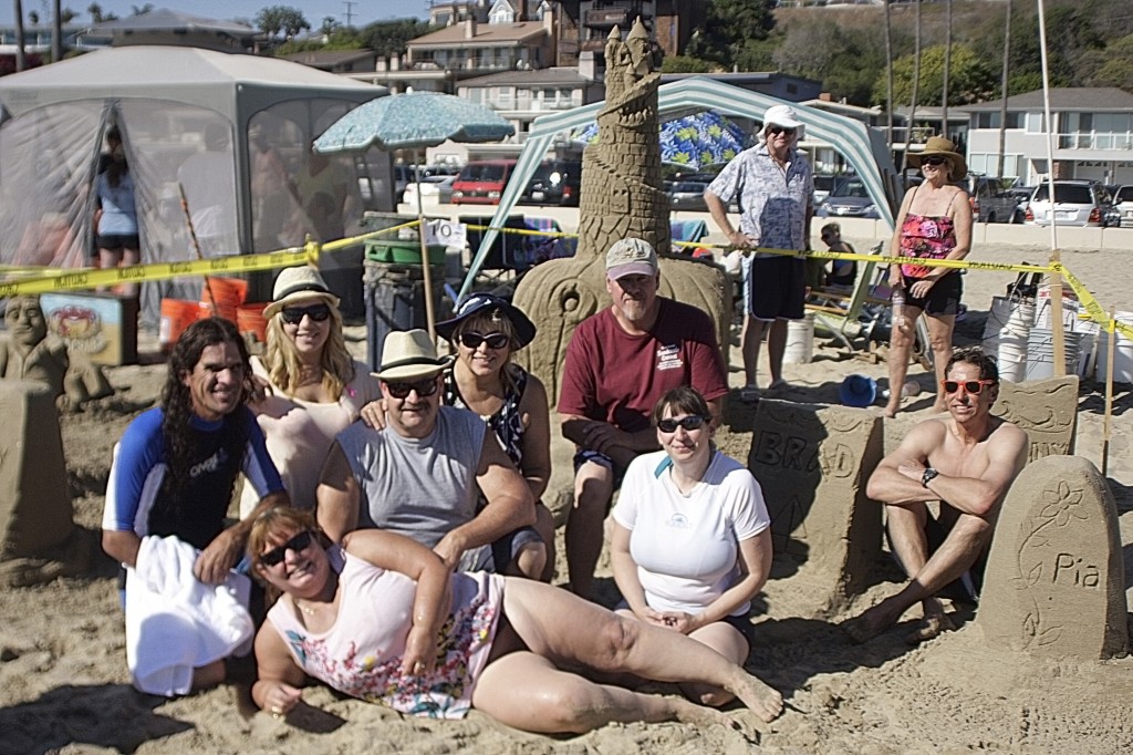 Team Beach Front Homes pose for a photo in front of their spooky sand sculpture.