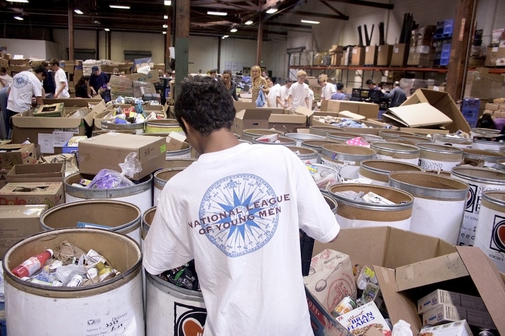 High school junior and NLYM member Ea Olotoa looks over all the bins of donated items at the Second Harvest warehouse in Irvine.