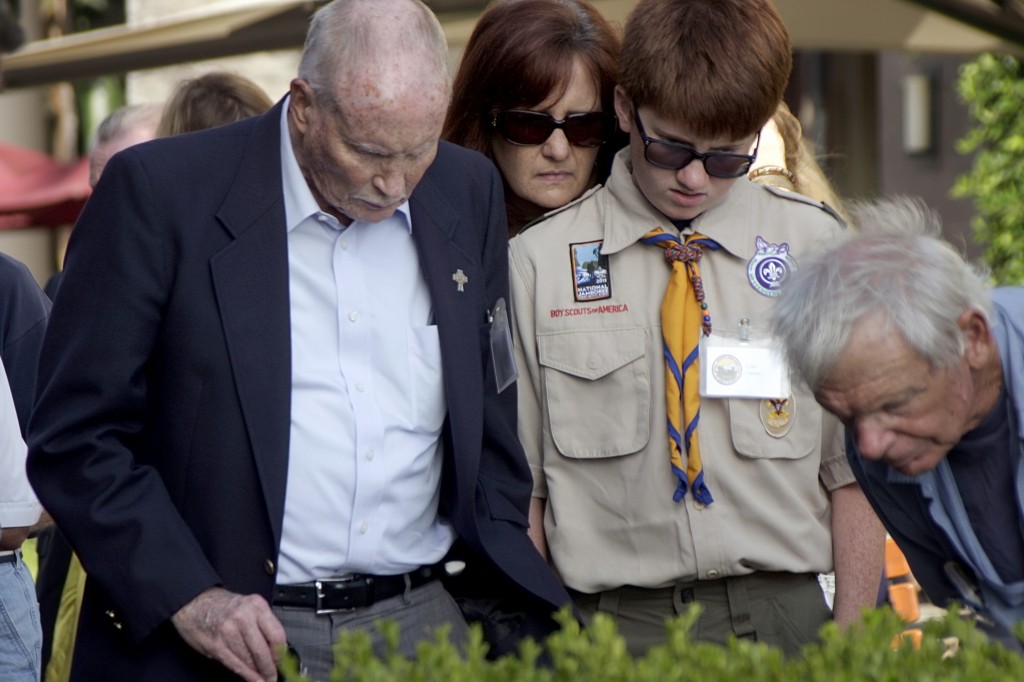 John Feeney, 76, (left) and his grandson Tyler Gaines, 13, who both participated in Boy Scouts of America Jamborees 60 years apart, along with Gaines’ mother, Pam, read the monument set up at Fashion Island to commemorate the 1953 event.