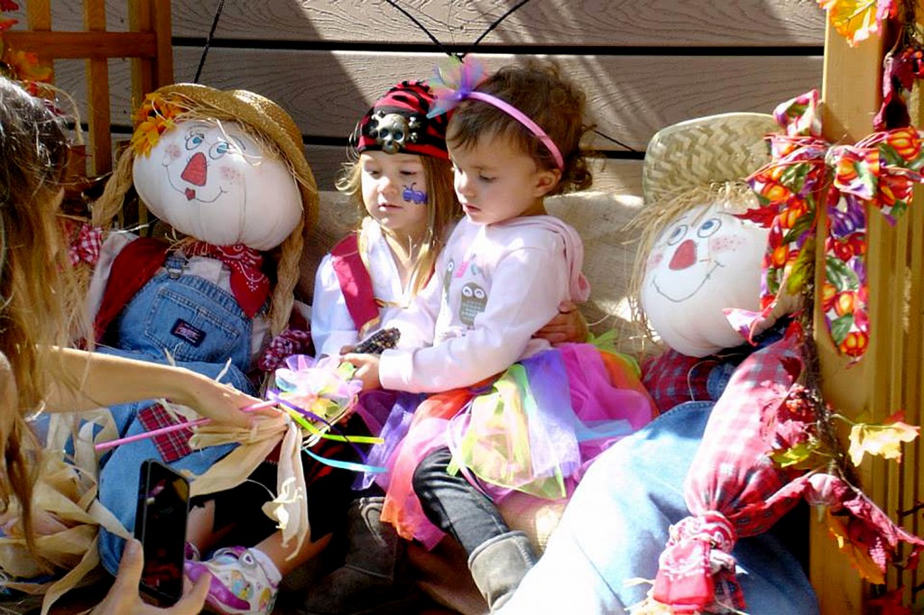 Some young girls are dressed up and ready to enjoy the Environmental Nature Center’s Fall Faire on Sunday as they pose for a photo by one of the center’s autumn themed decorations. — Photo by Lori Whalen