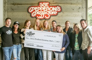 Sgt Pepperoni's Pizza co-owners Rob Dodman (left) and Jeff Roberts (right) present a check to representatives of Kaiser Elementary.