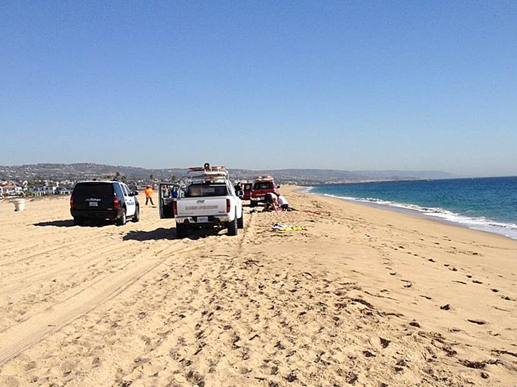 Crews work to rescue a man who jumped from a helicopter into the water near Balboa Pier on Tuesday. — Photo by Michelle Rousset