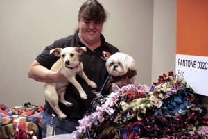 Tammy Osborn, of OC Animal Care, shows two of the shelter’s dogs, Barney (left) and Jack Frost, the blankets the group made on Wednesday. — Photo by Sara Hall