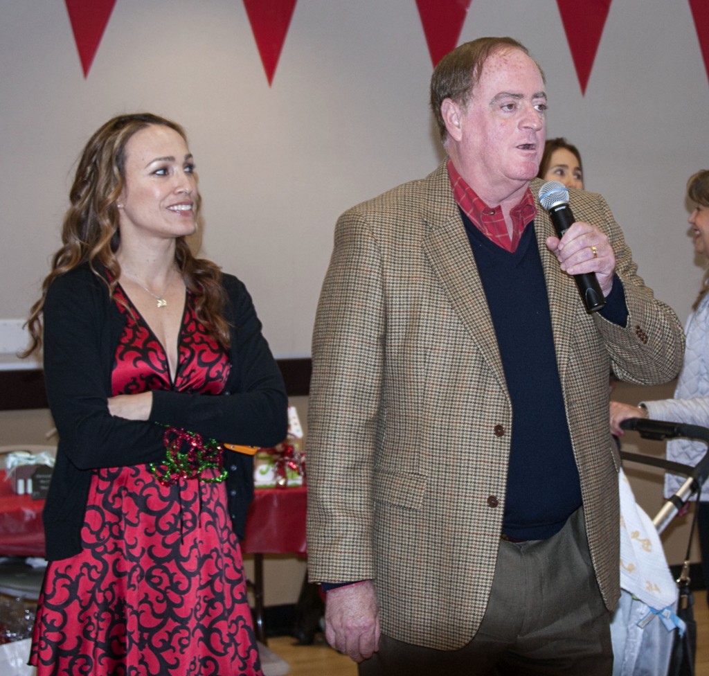 Newport Beach councilman Keith Curry speaks to the crowd at the carnival as event chair Sherry Roshan Fredrick looks on.