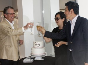 Retail consultant James Fleming toasts Gloria and Kevin Wu at their grand opening celebration.