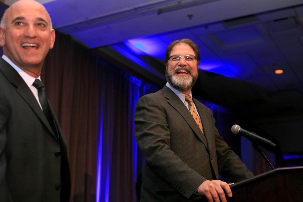 Orange County Supervisor John Moorlach (right) and President and CEO of the Newport Beach Chamber of Commerce, Steve Rosansky, laugh as Moorlach prepares to speak to the crowd.