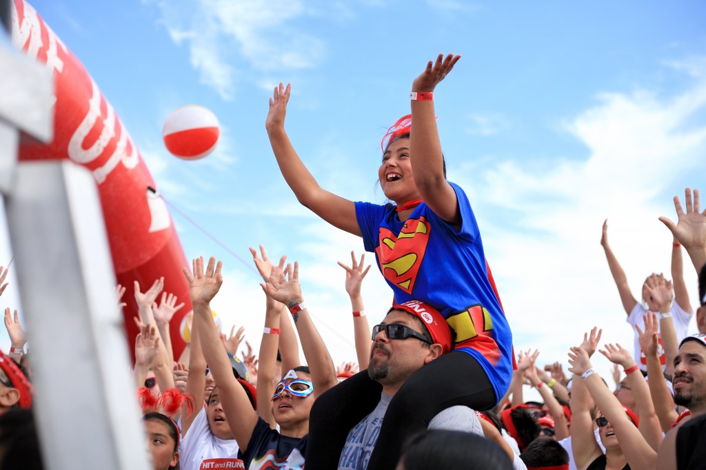 A young supergirl cheers as the announcer tosses prizes to the crowd before the Hit and Run 5K starts.