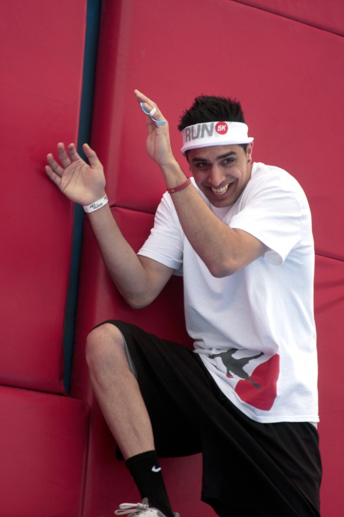 A racer tries to avoid red bouncy balls being thrown at him as he crosses the Whacking Wall.