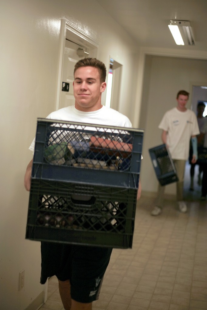 Cole Martin, 17, a junior at Corona del Mar High School, helps carry extra bibles to a storage room at the church on Saturday.