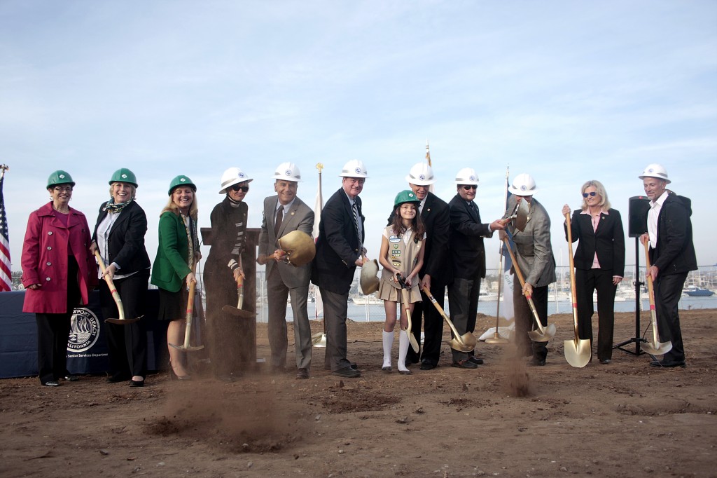 Officials break ground at the Marina Park site on Tuesday. From left to right: Girl Scouts of Orange County Board Secretary Christine Shingleton, GSOC CEO Nancy Nygren, GSOC Board Chair Julie Miller-Phipps, city council members Nancy Gardner, Tony Petros and Keith Curry, girl scout Olivia Bobrownicki, Mayor Rush Hill, Mayor Pro Tem Ed Selich, council members Mike Henn and Leslie Daigle, and city manager Dave Kiff.  — Photo by Sara Hall