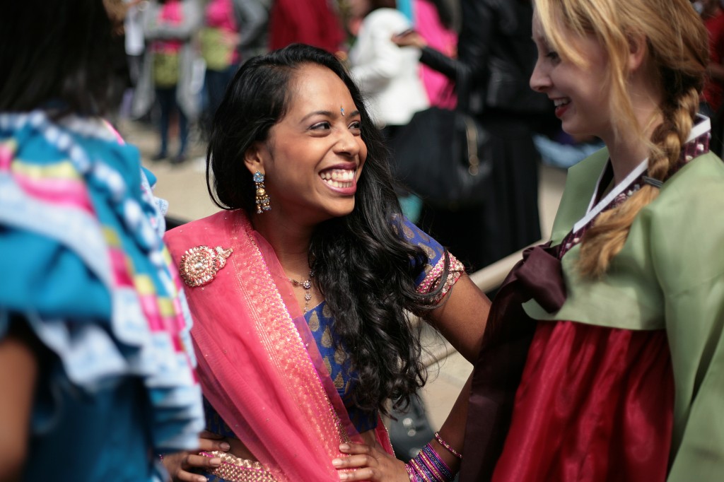 Wearing a gagra choli, junior Rachana "Cha Cha" Pillai, 16, (center) laughs with classmate Becky Lynskey, 17, a senior wearing a traditional Korean hanbok, during the International Fashion Show.