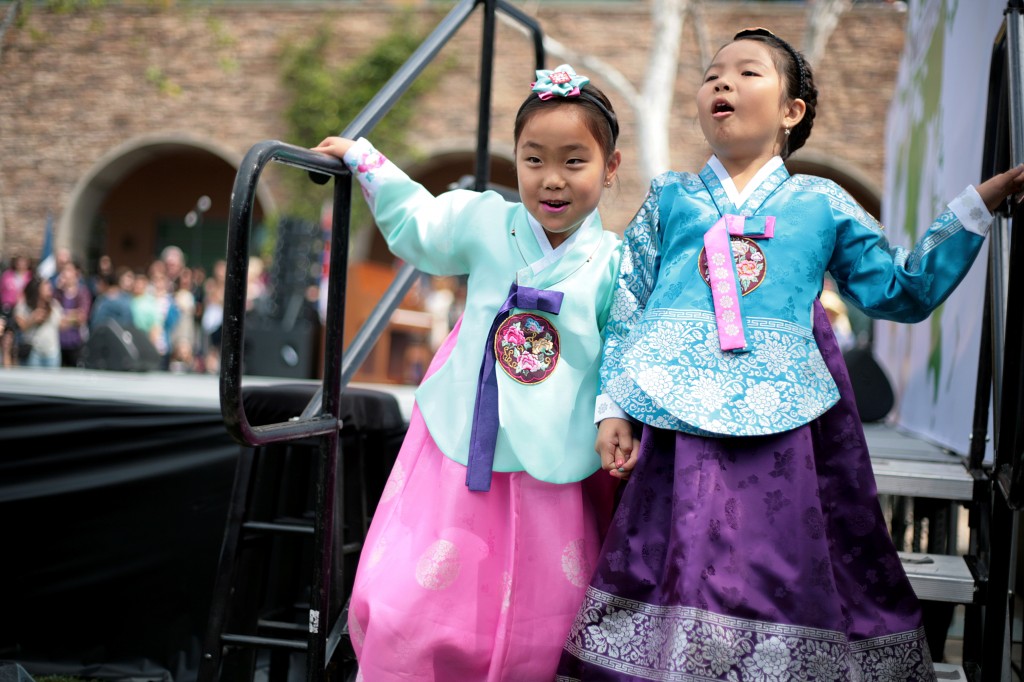 Wearing traditional Korean hanbok outfits, Lolla Rhee, 7, and Lauren Choi, 9, excitedly exit off the stage after participating in the International Fashion Show.